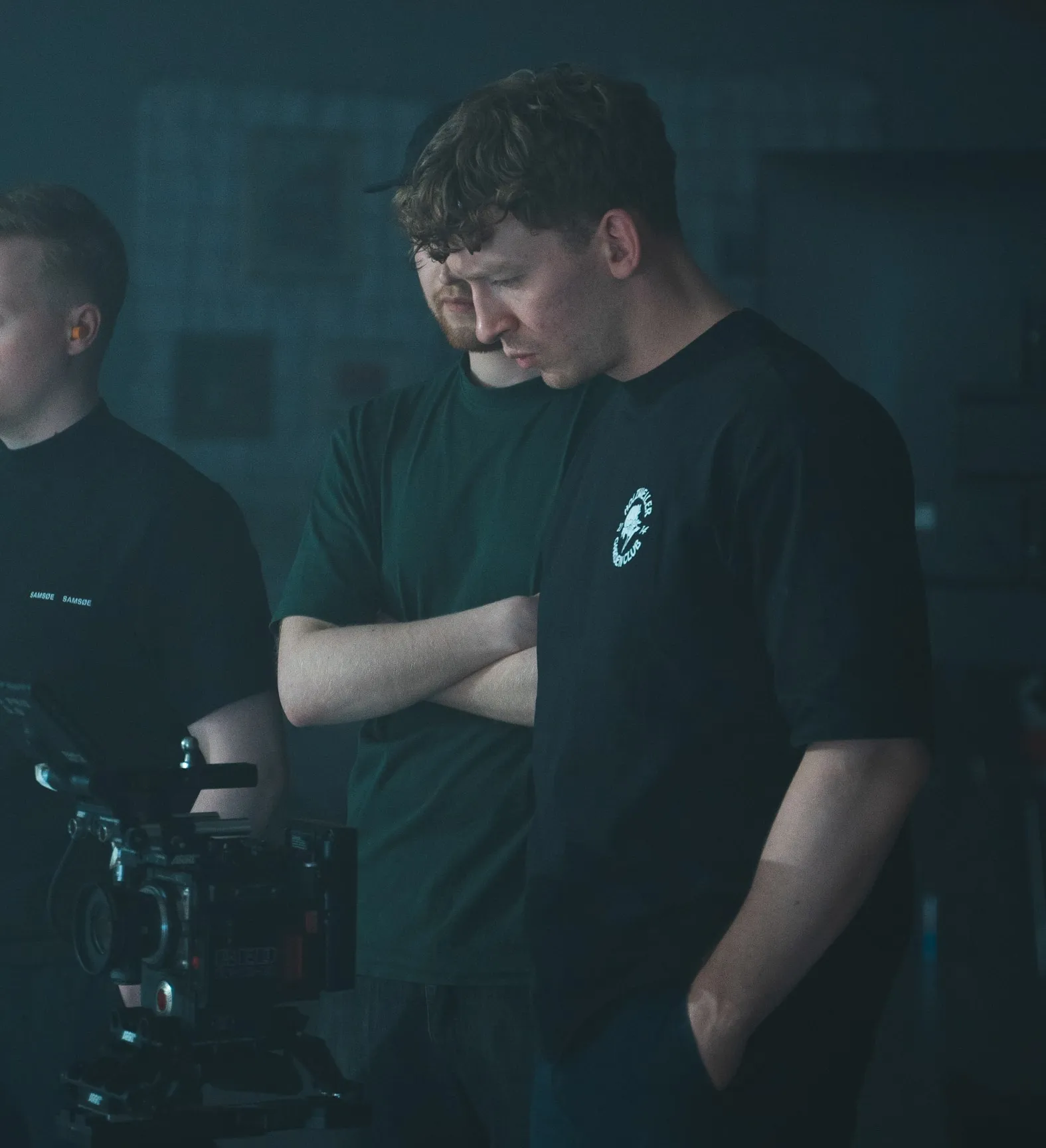 Trygve on a film set with two others, looking down at the camera